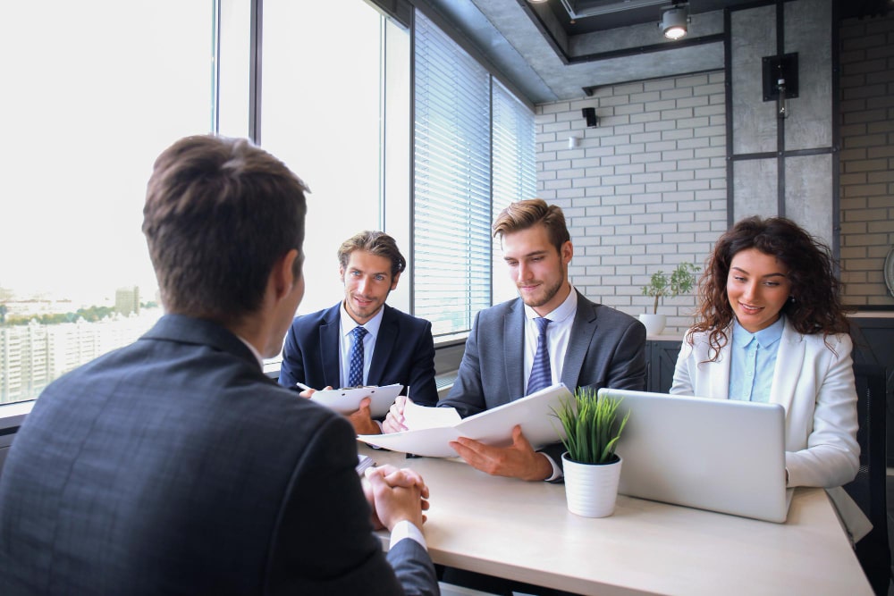 Business consultants meeting with clients in a modern office, representing TalentIQ Ireland’s HR advisory services that strengthen people, culture, and organizational performance.